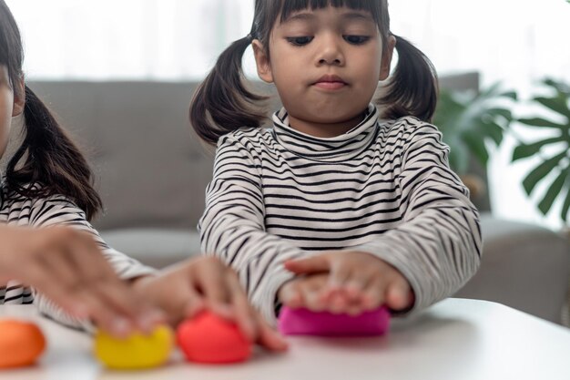 Asian kids play with clay molding shapes learning through play