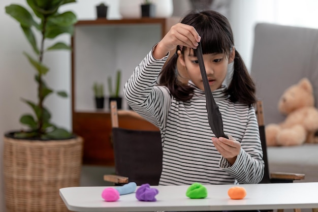 Asian kids play with clay molding shapes learning through\
play