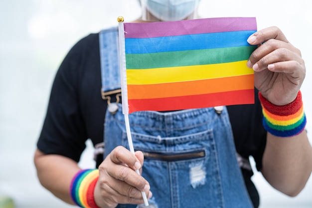 Asian lady holding rainbow color flag symbol of LGBT pride month