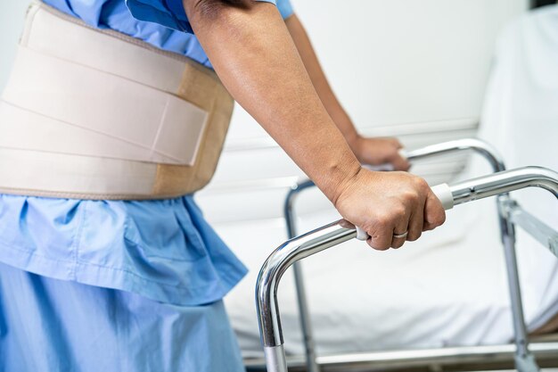 Фото Азиатская пациентка носит пояс для поддержки боли в спине для ортопедической поясницы с ходьбой