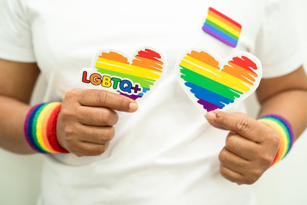写真 アジアの女性が虹の旗の腕輪をかぶり 心臓を握り lgbtプライドの月を象徴する 6月の毎年恒例のゲイ・レズビアン・バイセクシュアル・トランスジェンダーの人権社会を祝う