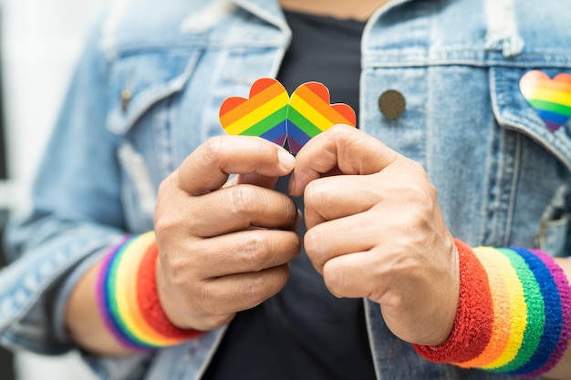 사진 lgbt 프라이드 월의 상징인 무지개 깃발 팔찌를 착용한 아시아 여성은 6월 게이 레즈비언 양성애자 트랜스젠더 인권의 사회를 축하합니다.