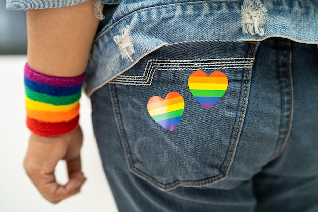 LGBT 프라이드 월의 무지개 깃발 심장 상징을 가진 아시아 여성은 게이 레즈비언 양성애자 트랜스젠더 인권의 6월에 연례 행사를 축하합니다