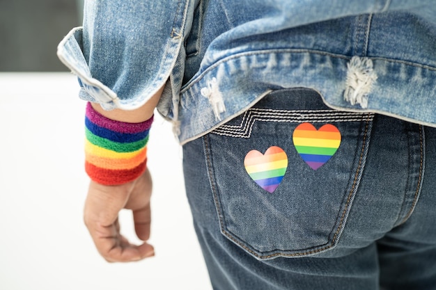 LGBT 프라이드 월의 무지개 깃발 심장 상징을 가진 아시아 여성은 게이 레즈비언 양성애자 트랜스젠더 인권의 6월에 연례 행사를 축하합니다