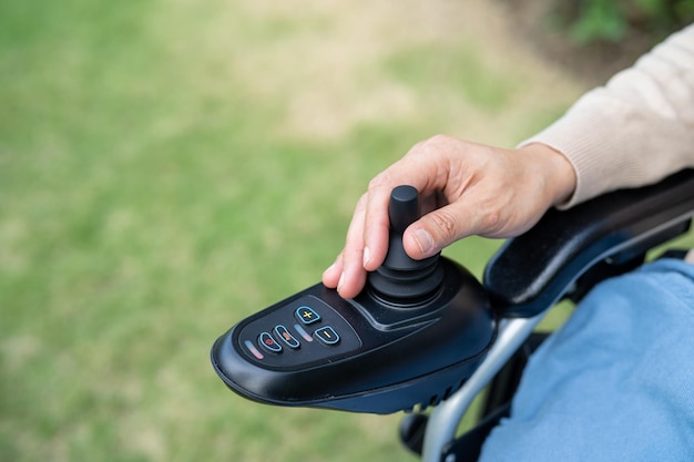 Asian lady woman patient on electric wheelchair with joystick and remote control at nursing hospital ward healthy strong medical concept