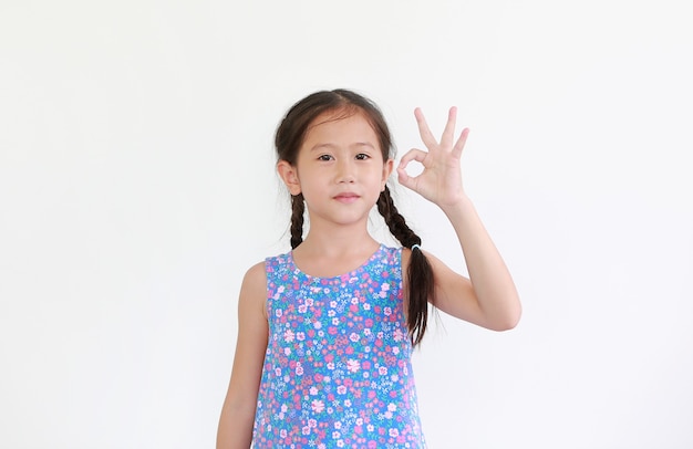 Asian little child girl show finger okay symbol sign language isolated on white