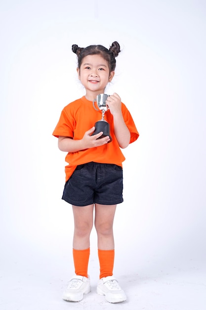 Asian Little Chinese Girl Smiles with a Trophy in Her Hands Isolated on White Background