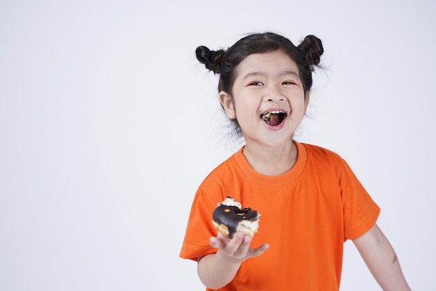 大きなドーナツを食べるアジアの小さなかわいい女の子