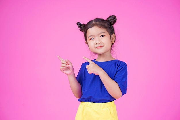 Asian little cute girl pointing something isolated on white background