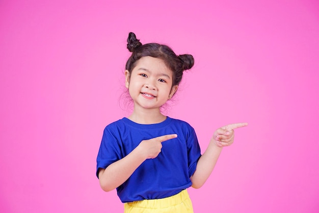 Asian little cute girl pointing something isolated on white background