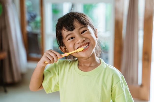 Asian little girl brushes her teeth