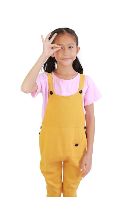 Азиатская маленькая девочка показывает пальцы, выбирая что-то пустое на лице на белом фоне