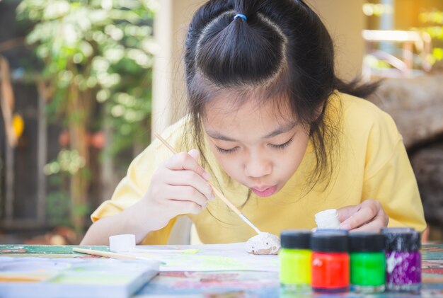 Pietre da colorare ragazza asiatica, bambini creativi artigiano rock, concetti di bambini di creatività