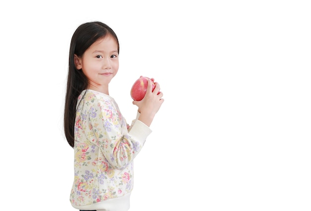 Asian little girl holding red apple in hands on white