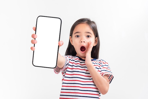 Asian little girl holding smartphone mockup of blank screen and smiling on white background