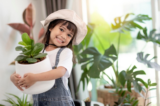 La bambina asiatica sta piantando piante nel concetto di casa di attività di apprendimento per la coltivazione di piante per un bambino in età prescolare e educazione del bambino per l'albero in natura