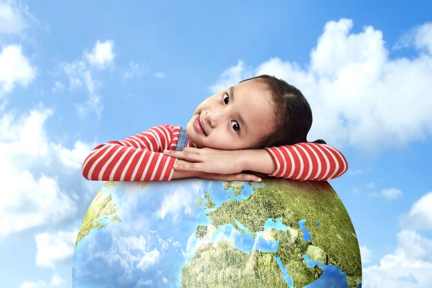 Asian little girl leans on the earth. World Children Day