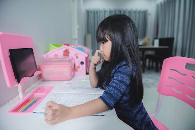 Asian little girl learn online at homein the era of the covid19\
epidemic it is not possible to go to school normally