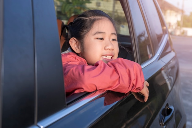 Asian little girl looking something out the car.