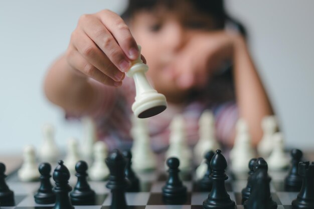 Asian little girl playing chess at homea game of chess