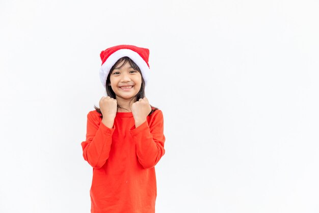 Asian little girl in red Santa hat on white background.