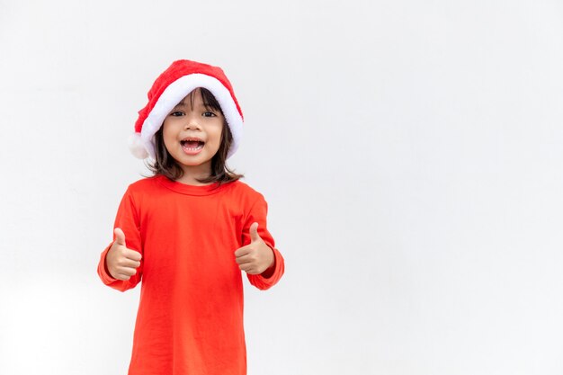 Asian little girl in red Santa hat on white background.