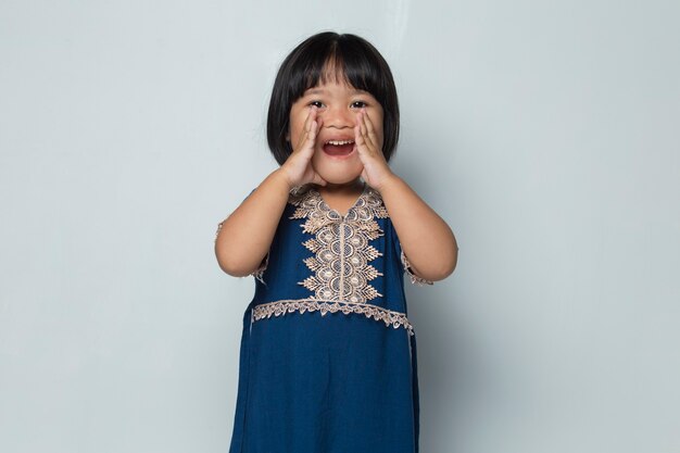 Asian little girl shouting and yelling announcing isolated on white background