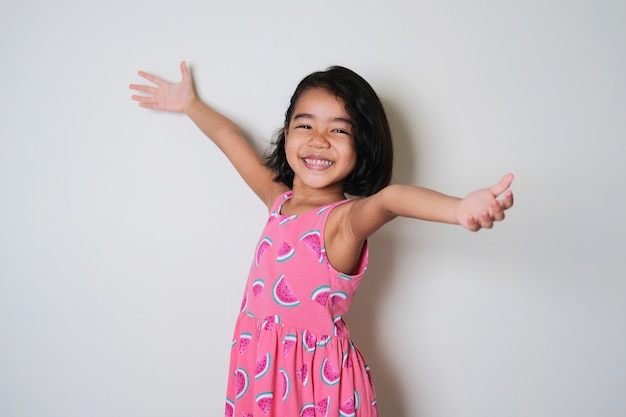 Азиатская маленькая девочка показывает счастливое возбужденное выражение с распростертыми объятиями