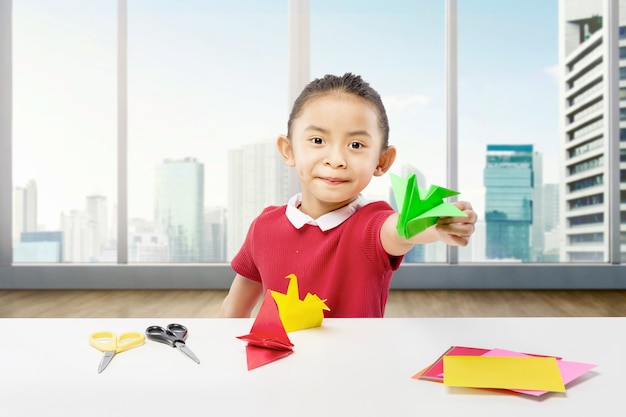 Asian little girl showing her goose paper at home