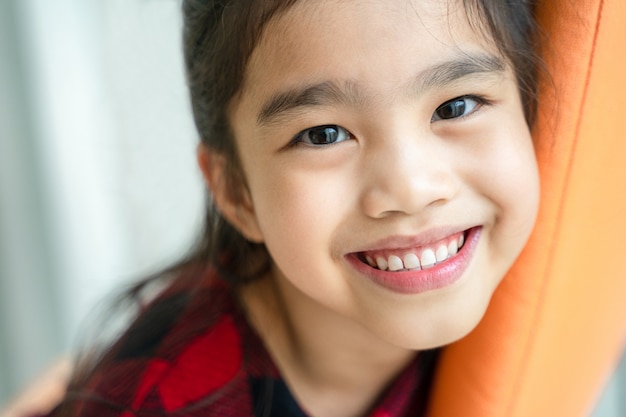 Азиатская девочка улыбается с идеальной улыбкой и белые зубы в стоматологической помощи