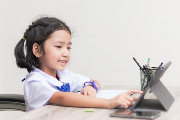 Asian little girl in student uniform doing homework