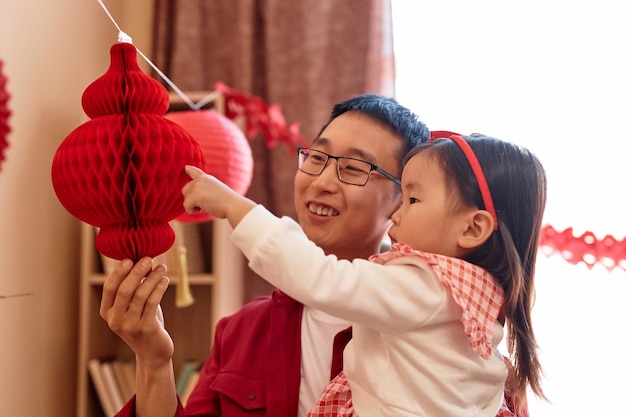 Photo asian little girl with father preparing for chinese new year