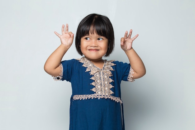 Asian little girl with ok sign gesture tumb up isolated on white background