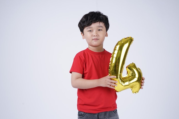 Asian little kid boy happy smile with foil number balloon, isolated on white background