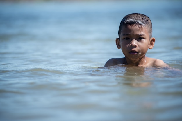 Asian little kid play in water and making splash