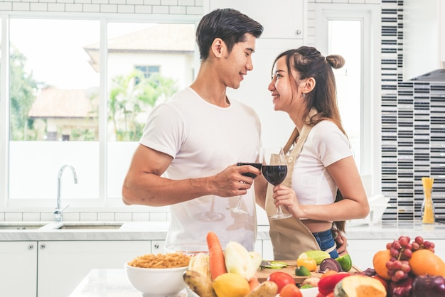 Asian lovers or couples drinking wine in kitchen room at home