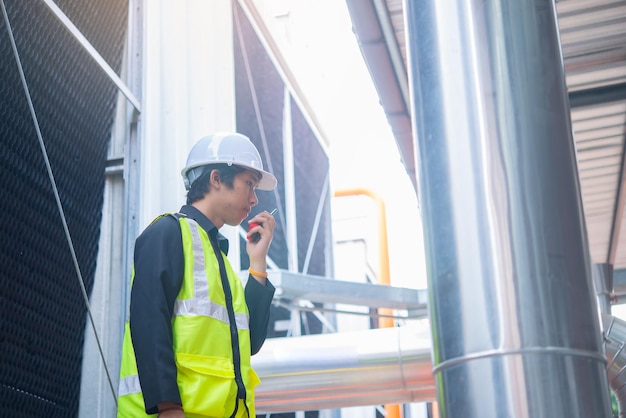 Asian maintenance engineer at the waste water management system
of a huge factorymaintenance checking technical data of heating
system equipmentthailand people