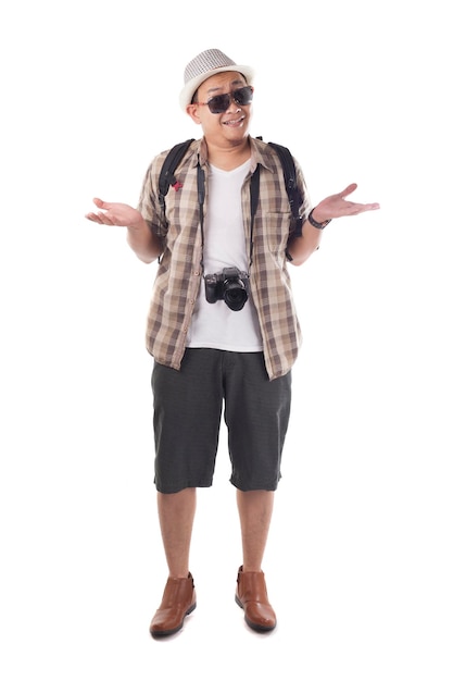 Азиатский мужчина с рюкзаком, турист в шляпе, солнцезащитные очки, камера, запутанный жест, пожимание плеч.