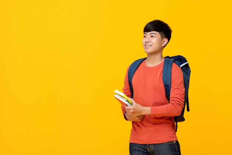 Photo asian male college student with backpack holding books