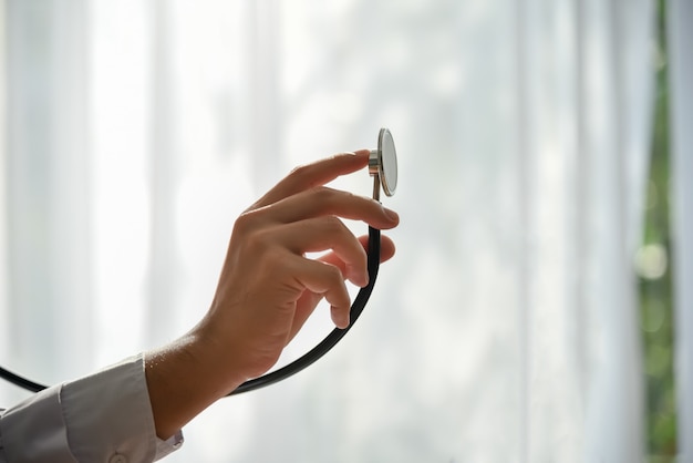 Asian male doctor holding Stethoscope which is a device To check the patient's symptoms