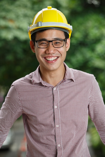 Asian male engineer with a yellow hard hat