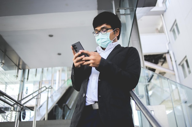 Asian male freelancer wearing surgical mask going to work in the morning on the subway