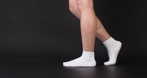 Asian Male legs wear white sock is isolated on black background