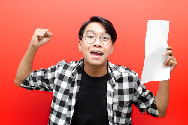 asian male students or worker with glasses feels glad while holding blank paper work.