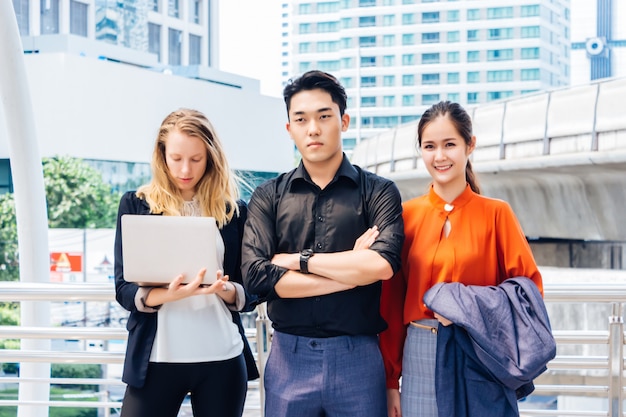 The Asian male supervisor stood with arms folded beside the two female secretaries. 