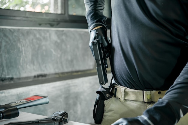 Asian male wearing black leather gloves with gun in handkeep gun in the Holster