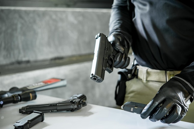 Asian male wearing black leather gloves with gun in handloading bullets to gun