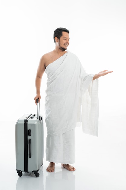 Asian male with ihram presenting copyspace