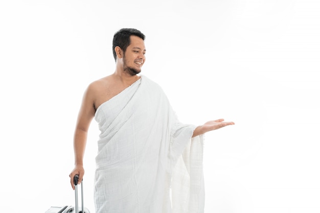 Asian male with ihram presenting copyspace