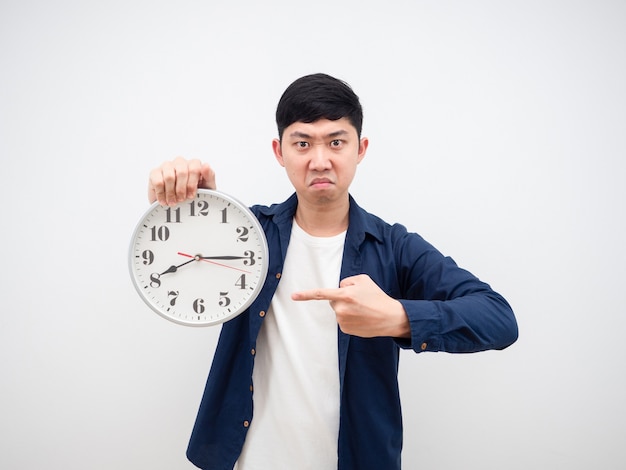 Asian man angry face point at clock 15 minute past 8 am in his hand working late concept on white